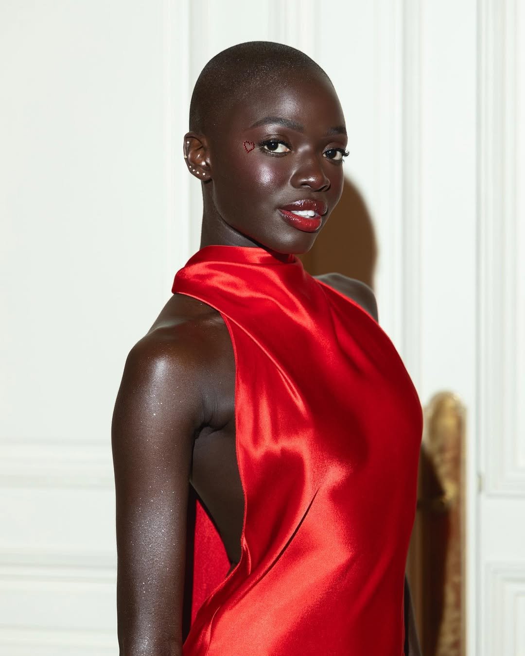 Pessoa com vestido vermelho e  batom vermelho para iniciantes , com detalhes sutis no rosto.