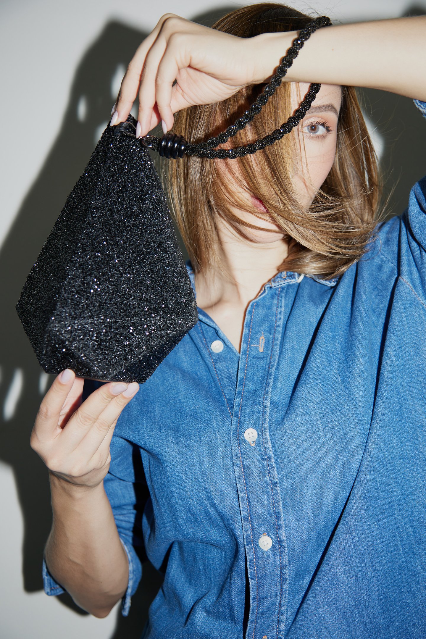 divulgação da campanha de lançamento da coleção Diamond Essence da marca Soleah. Na foto a modelo usa camisa jeans e segura a bolsa baby diamond 