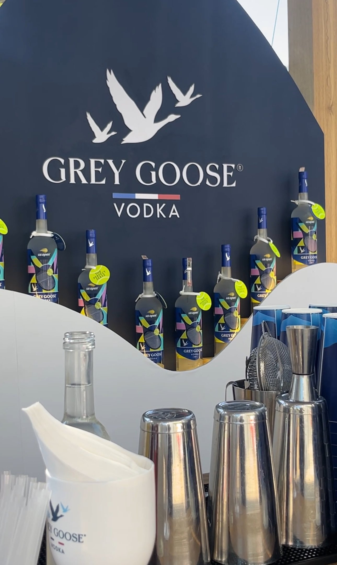 Garrafas de vodka em exposição com copos e utensílios de bar no Rio Open.