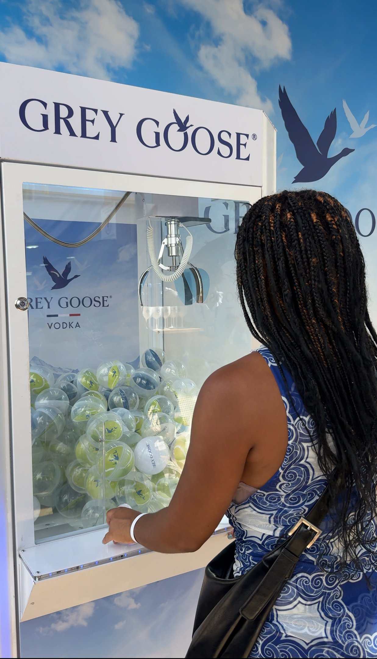Inaê Ribeiro na máquina de pegar brindes da Grey Goose durante o Evento Rio Open.