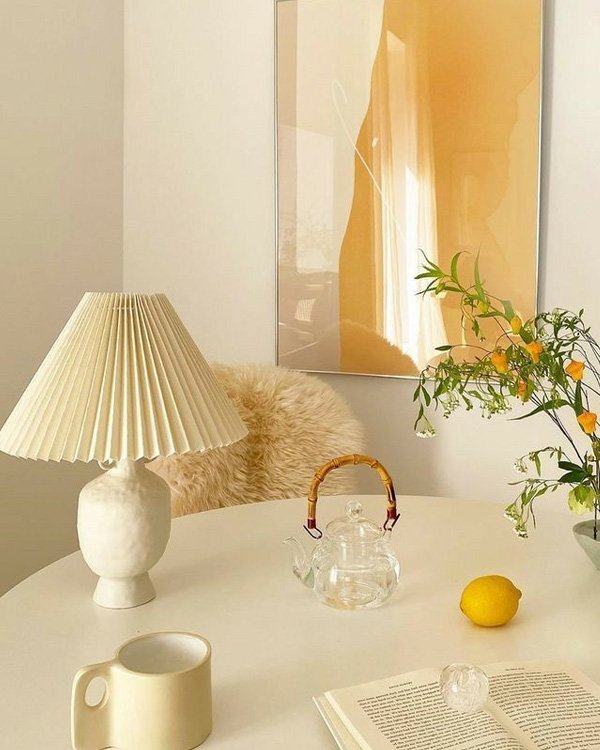 Mesa decorada com lamparina elegante, bule de vidro, limão e flores, ideal para decorar a casa com um toque de sofisticação.