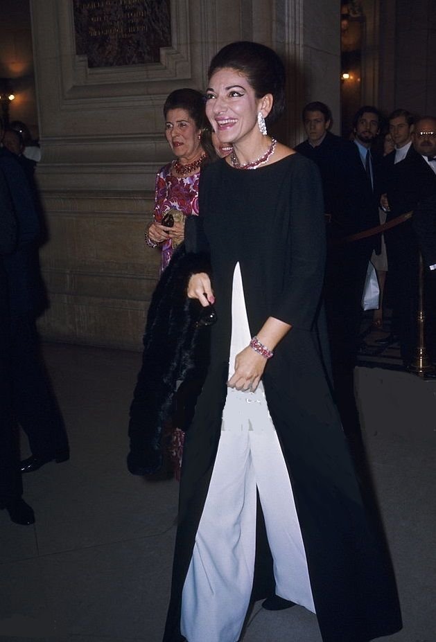 Maria Callas em evento, vestindo traje sofisticado. atmosfera luxuosa e iluminada.