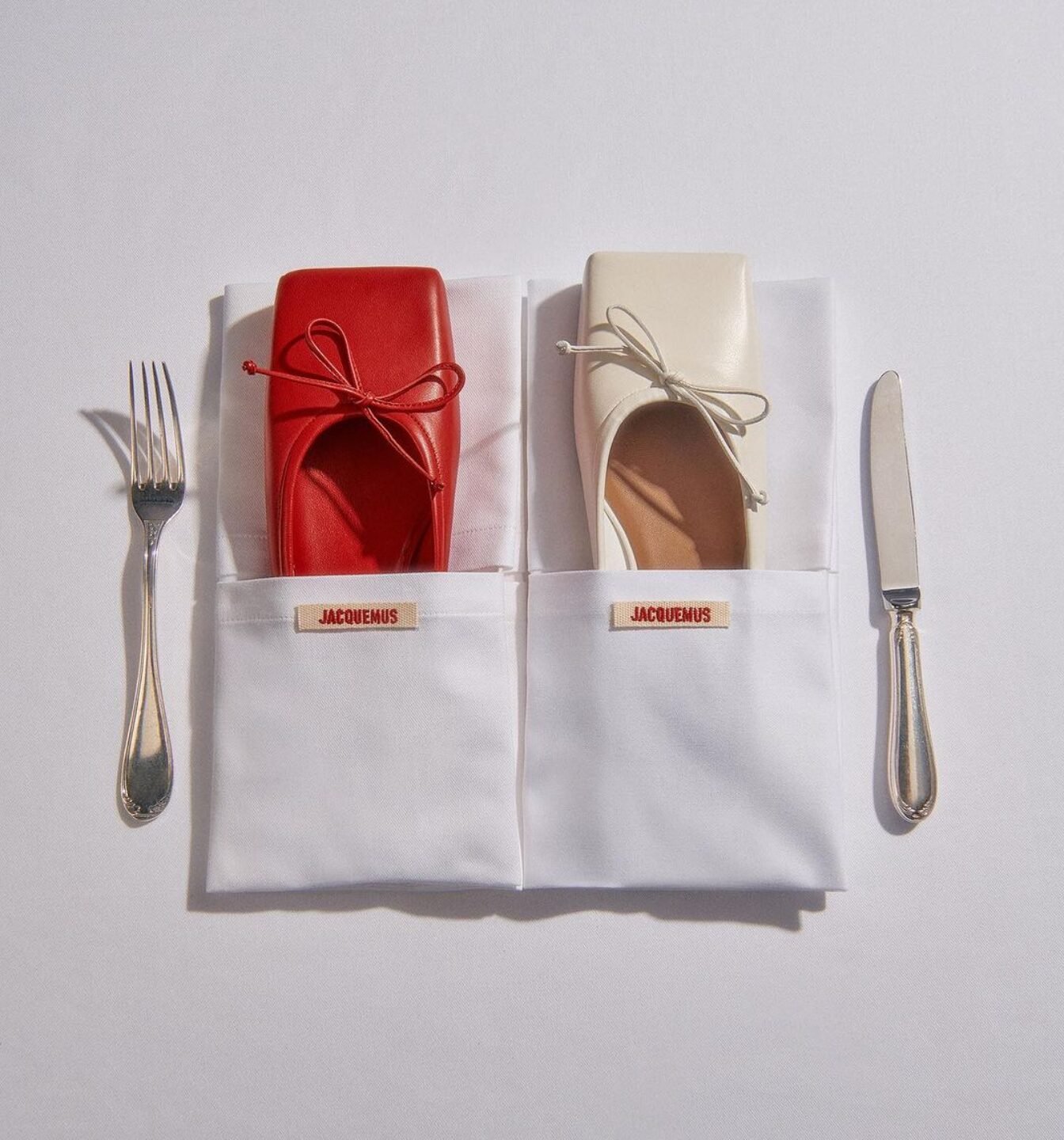 Sapatos vermelhos e brancos em guardanapos ao lado de talheres, misturando moda e comida.
