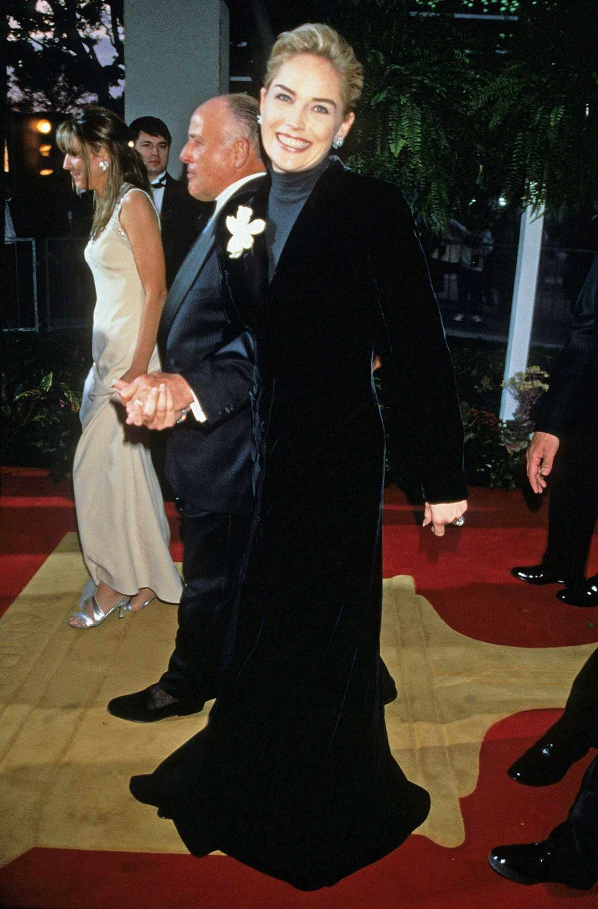 Pessoa sorridente usando vestido elegante em um evento, destacando looks do tapete vermelho.