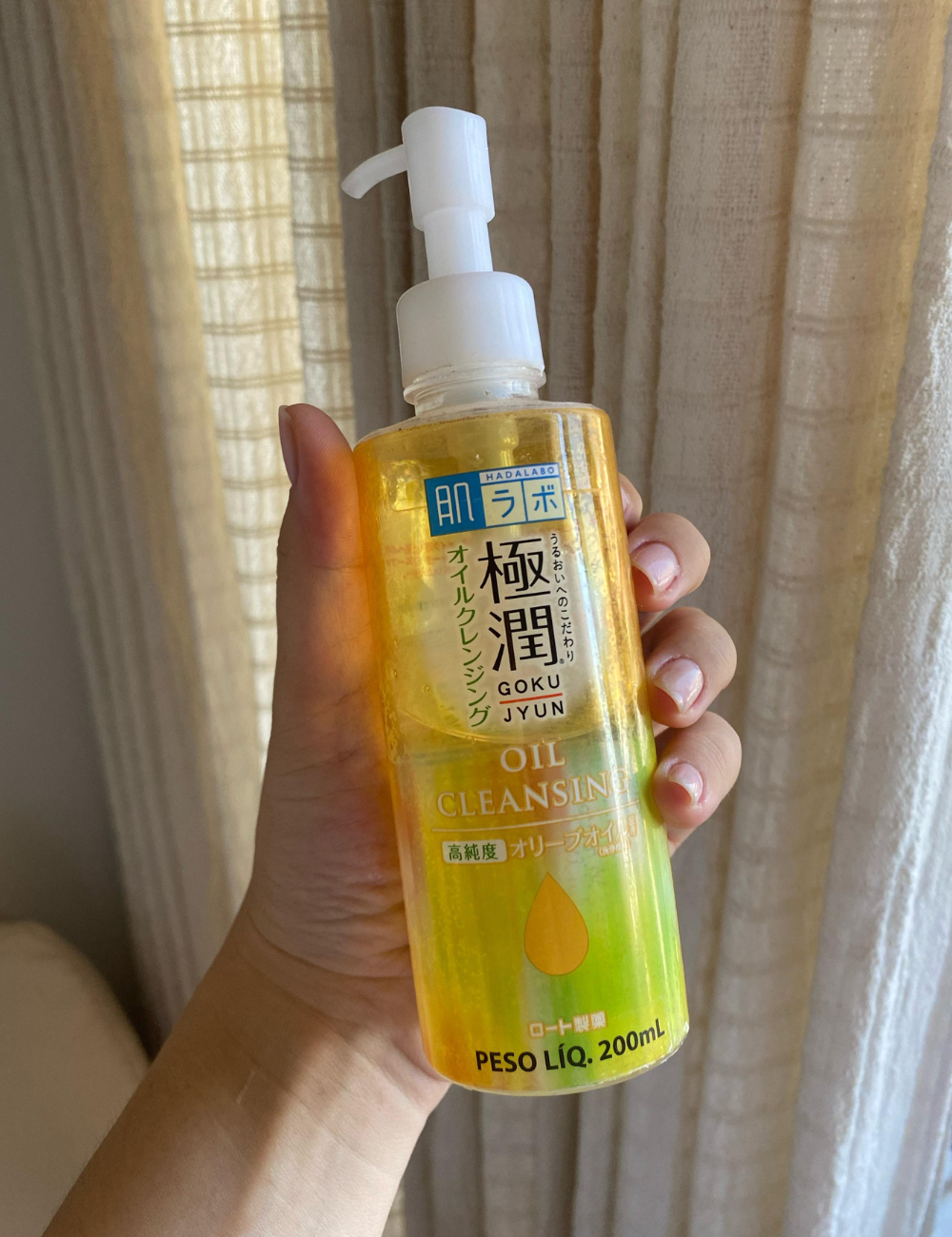 Produto de limpeza facial líquido com 200 ml, embalado em frasco transparente com rótulo amarelo. Tipos de cleansing oils.