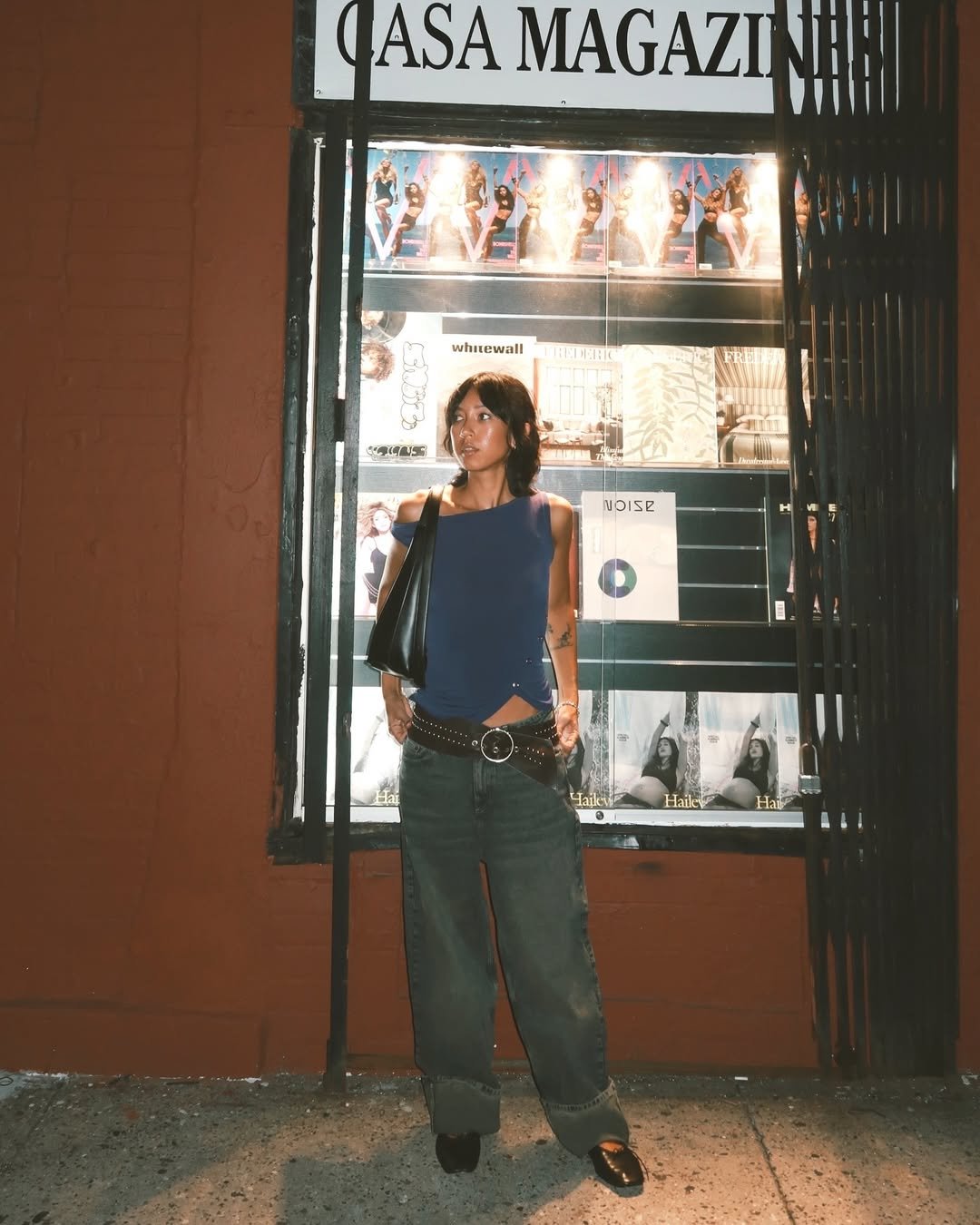 influenciadora usando blusa tomara que caia preta, scarpin e calça jeans oversized