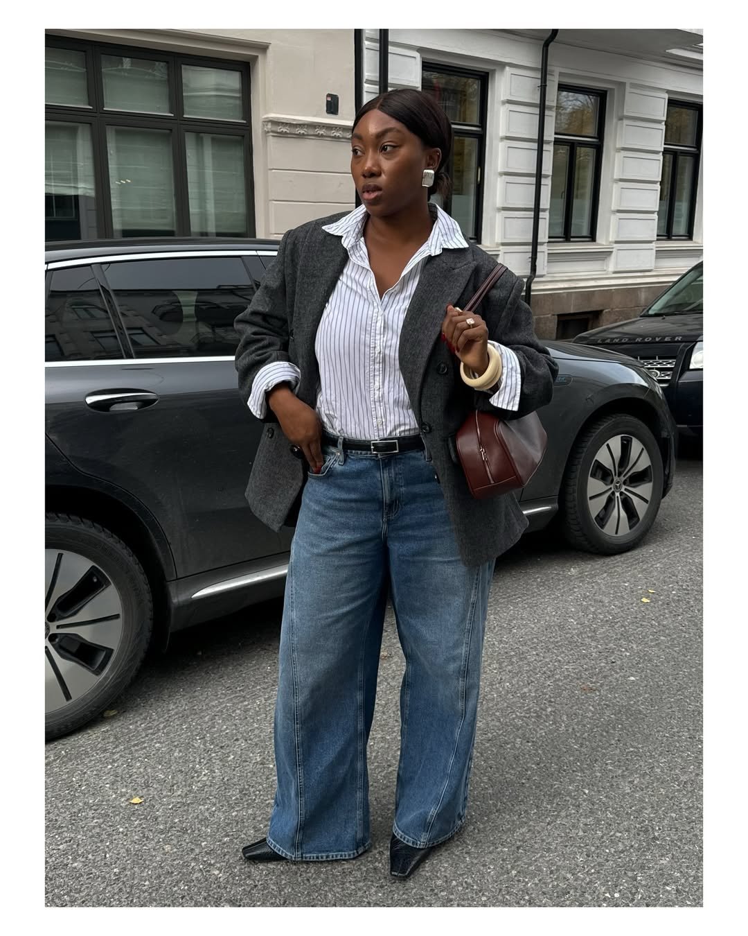 influenciadora usa camisa branca, casaco e calça jeans oversized