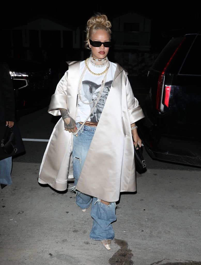 Desculpe, não sei quem é a pessoa na imagem. Look moderno com óculos escuros, casaco claro e jeans rasgados. Truques de styling da Rihanna