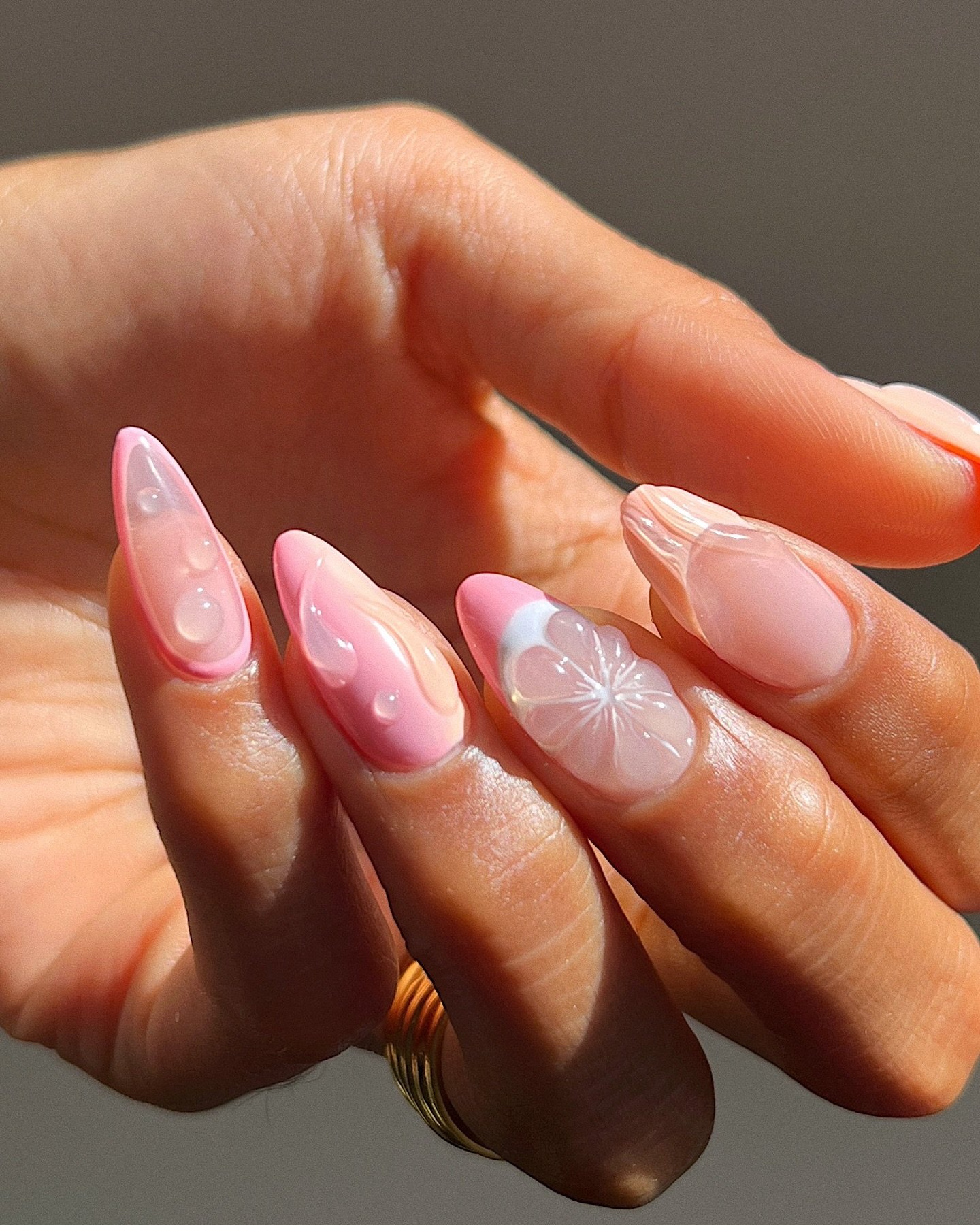 Unhas com design 3D em tons de rosa e nude, com detalhes em relevo e desenhos florais.
