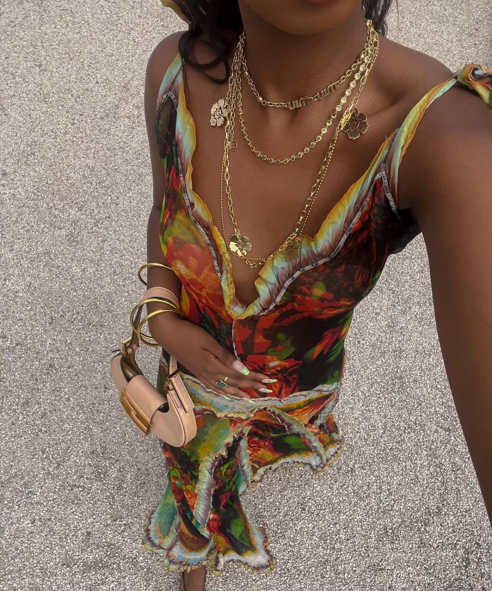 Vestido colorido e acessórios dourados em passeio de verão em Ibiza.