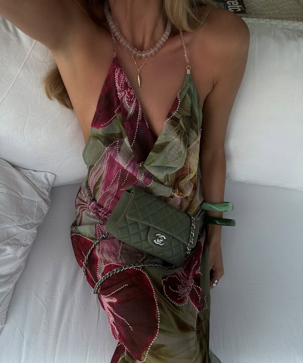 Vestido floral e bolsa verde combinando em um ambiente descontraído de verão.