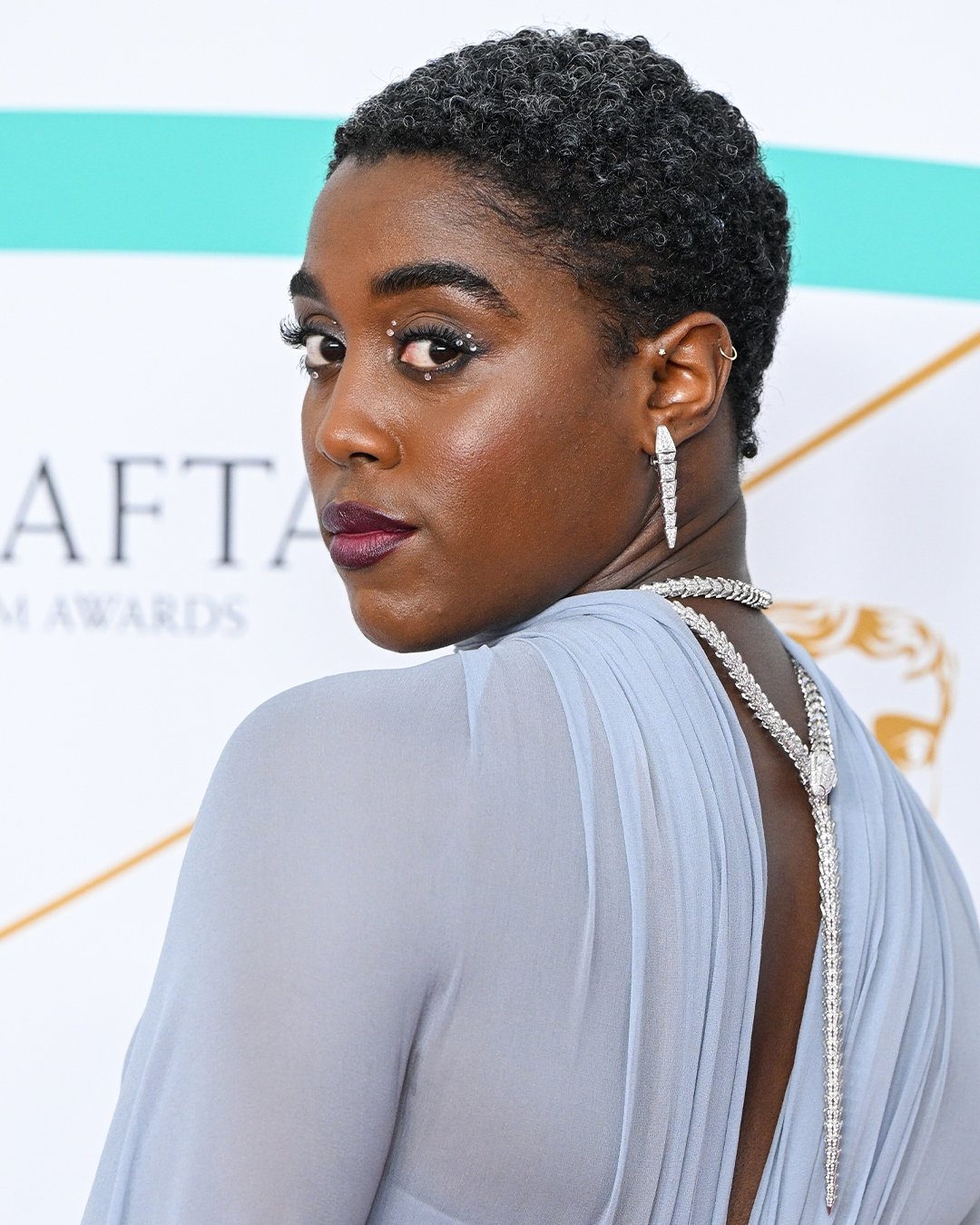 Pessoa usando um elegante brinco brilhante e penteado curto. Acessório tendência do red carpet destaca-se.
