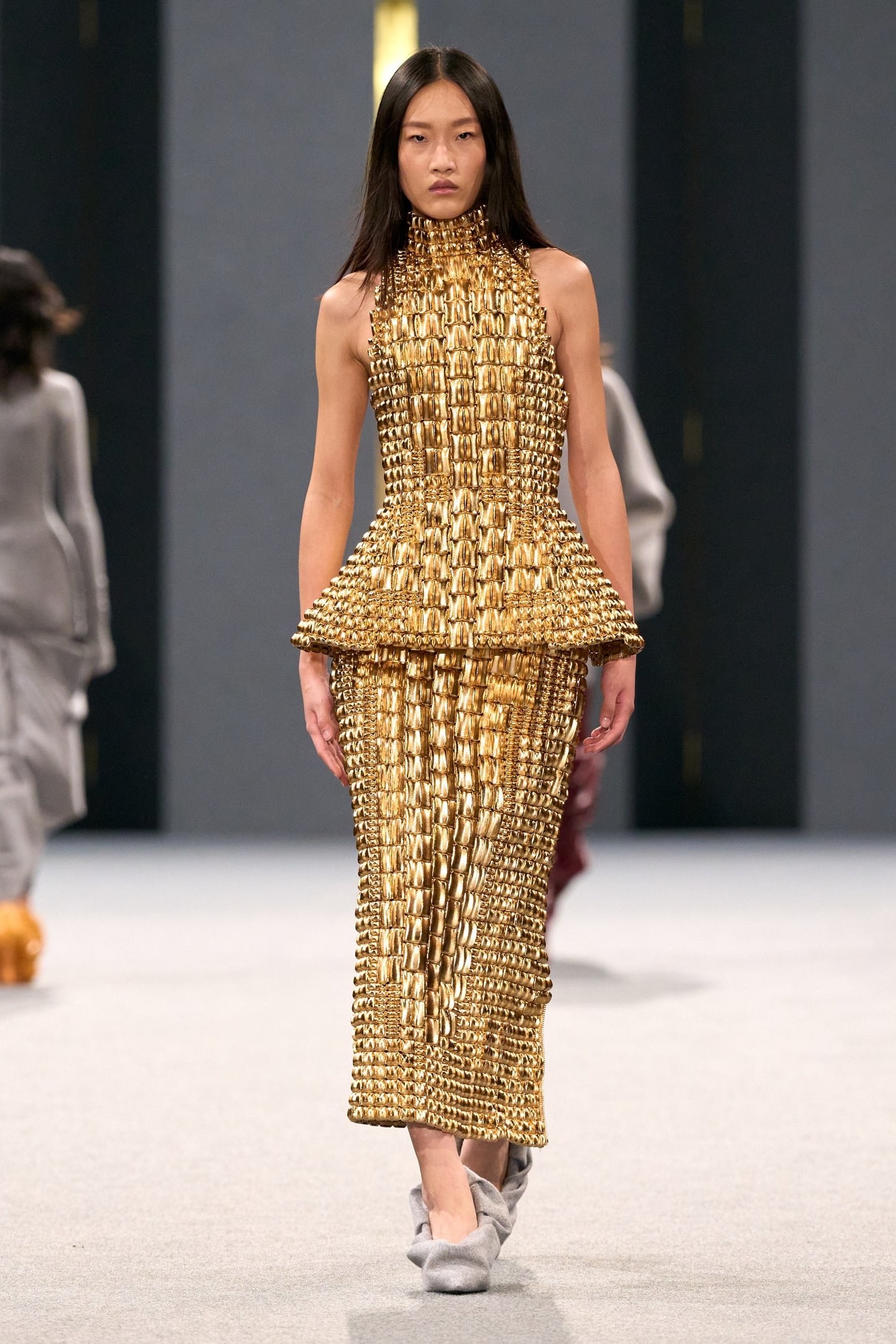 Modelo em traje dourado texturizado no desfile da Balmain.