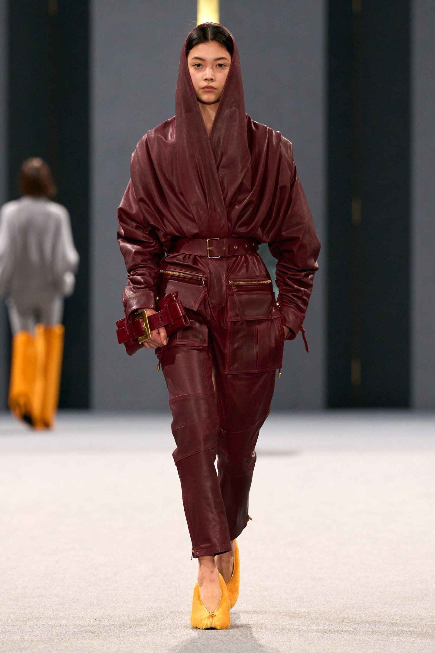 Modelo usando conjunto vermelho profundo e sapatos amarelos no desfile da Balmain.
