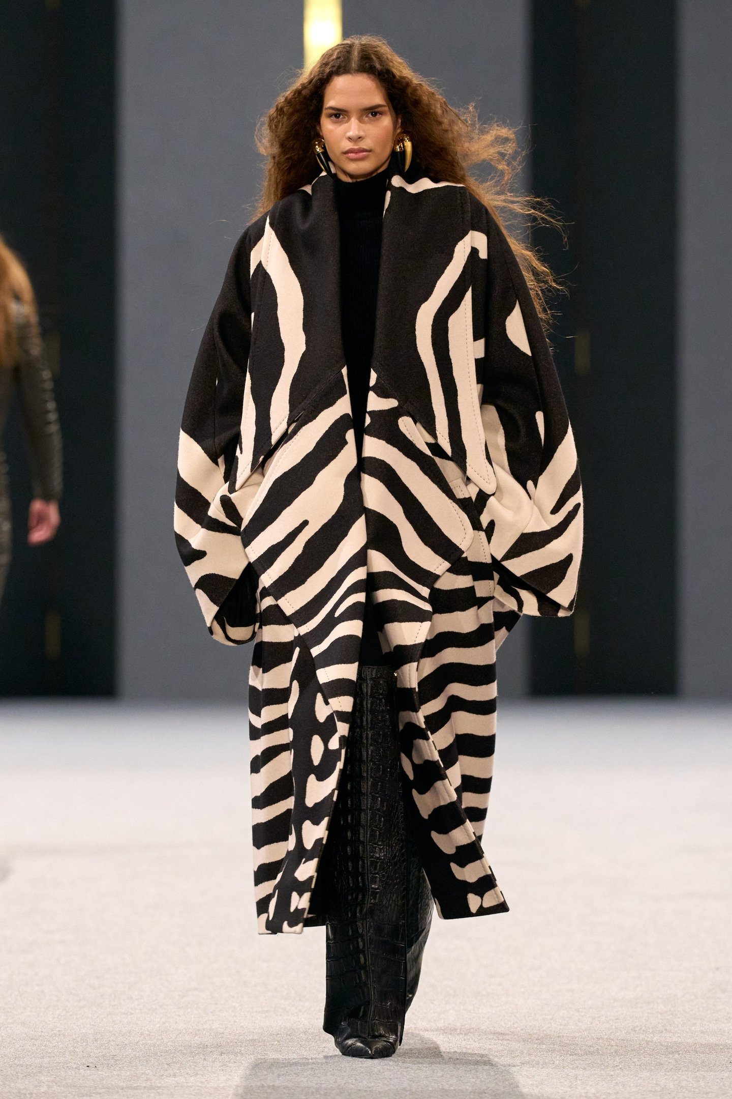 Modelo com casaco preto e branco com estampa de zebra no desfile da Balmain.
