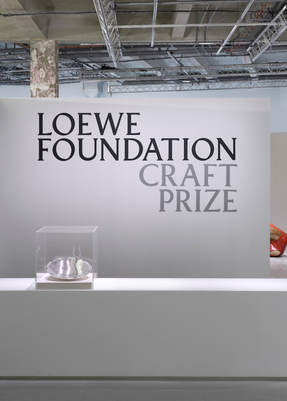 Paredes com logotipo da Loewe Foundation Craft Prize, com escultura em vitrine. 