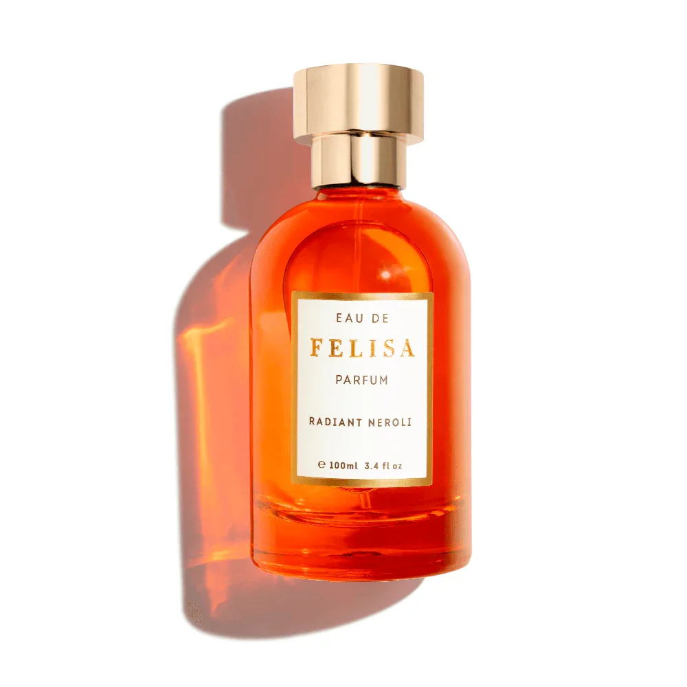 Frasco de perfume feminino com design elegante, em tom laranja, rotulado 