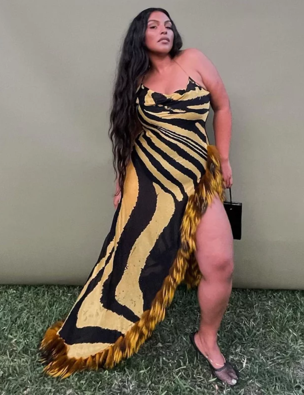 Vestido com estampa animal print, realçado por franjas, usado com referência nas tendências atuais da moda.