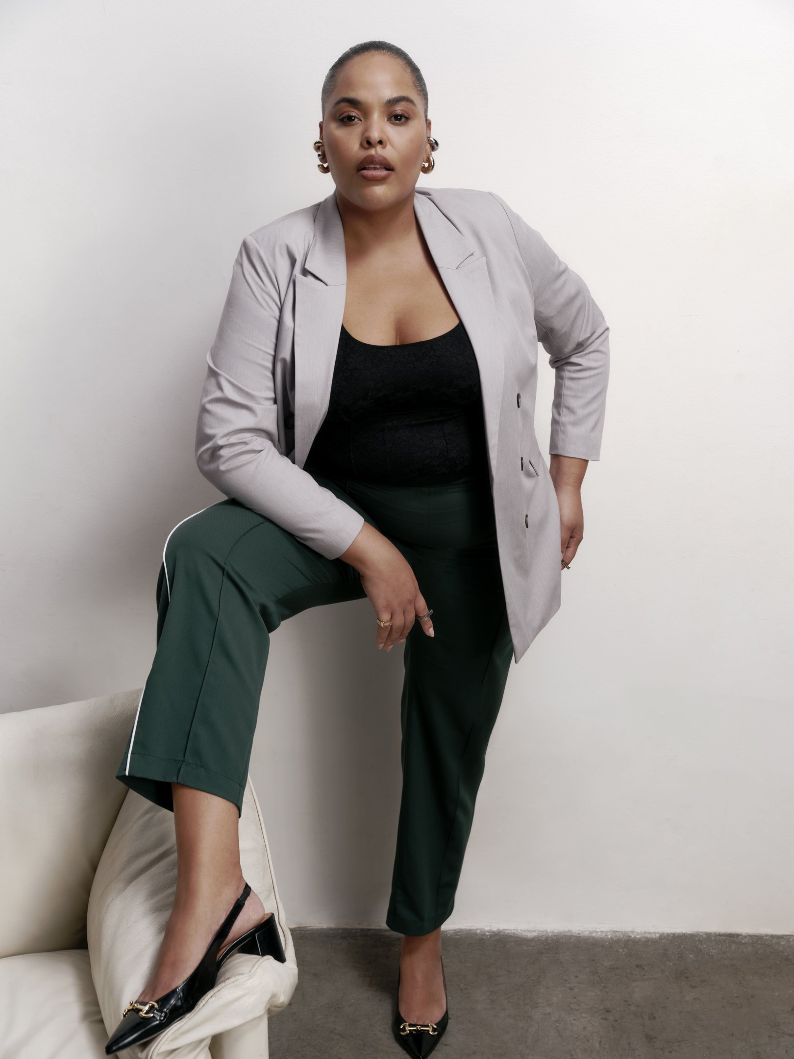 modelo posando com calça, blazer e scarpin do estilo preppy