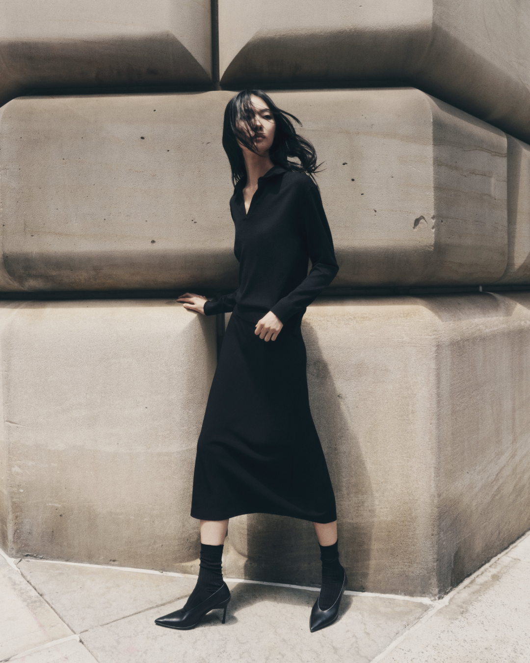 modelo usando vestido preto feito com matéria prima premium para ser usado nos looks de meia estação