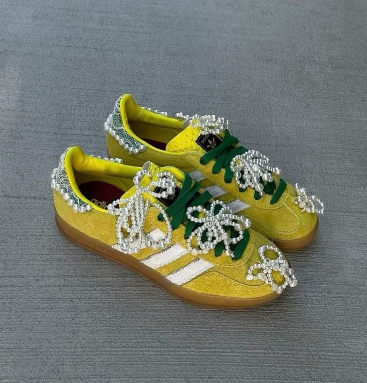 Tênis amarelos com detalhes de Charms feitos de pérolas e cadarços verdes.