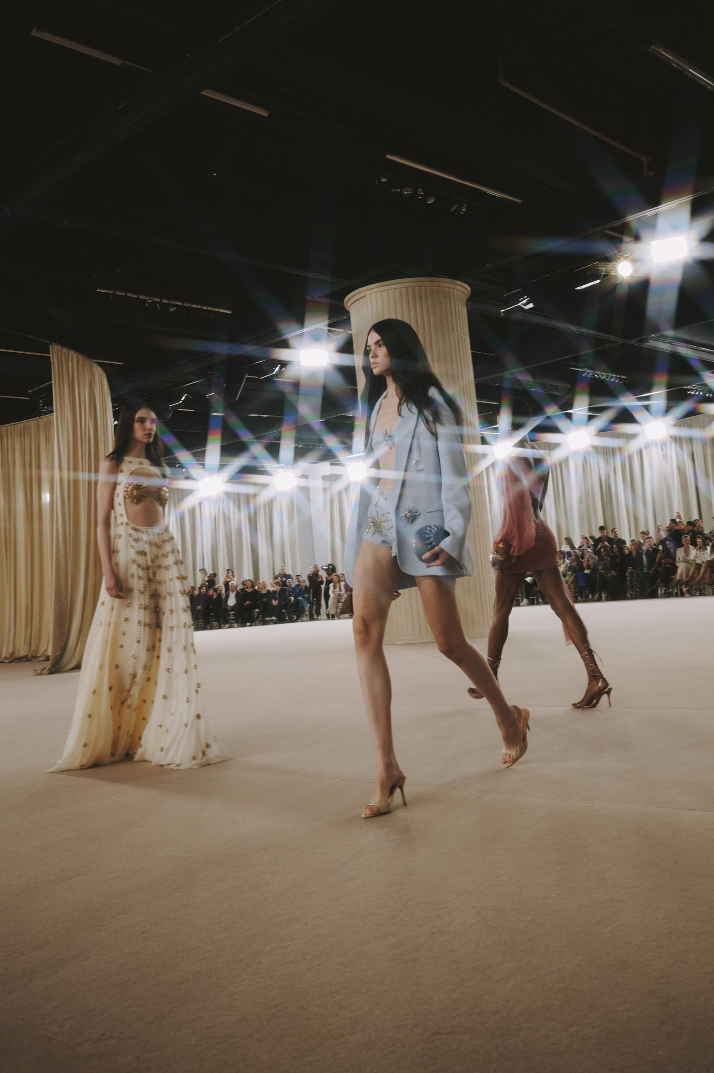 Desfile de moda com modelos usando roupas elegantes, refletindo tendências de verão.