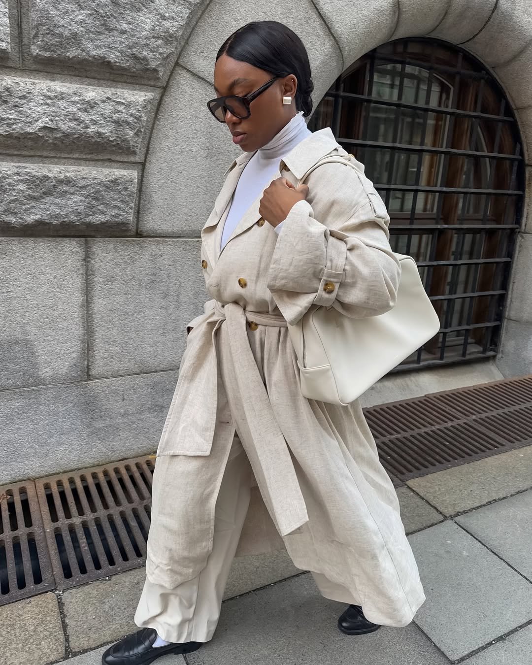 influenciadora usando trench coat, uma das peças de roupa atemporais para investir