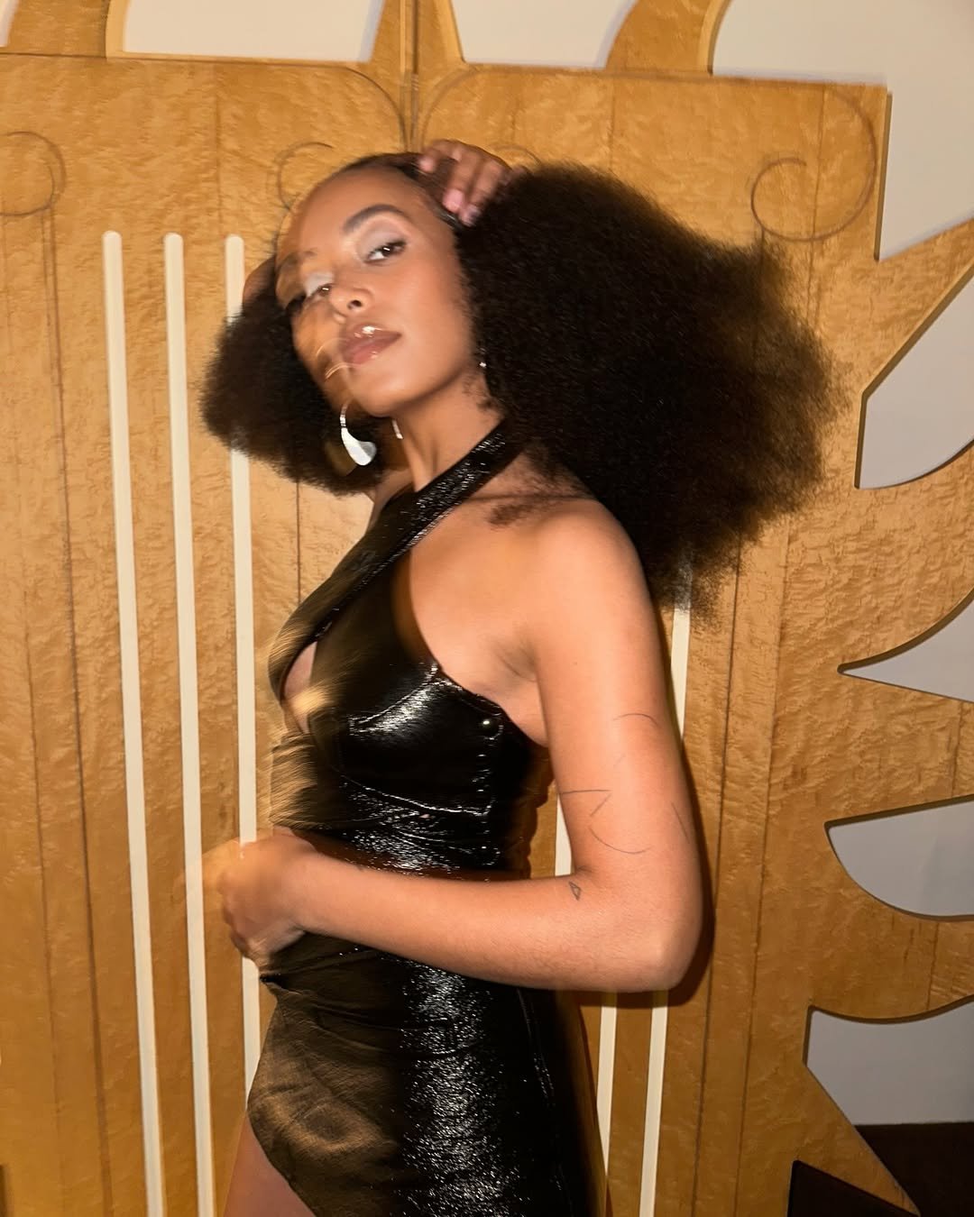 Solange Knowles vestindo um vestido preto, com cabelo volumoso.