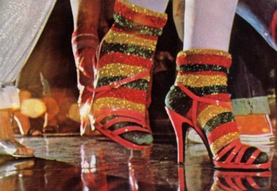 Sapatos de salto alto dançando com meias coloridas com listras brilhantes, evocando estilo vibrante e retrô.