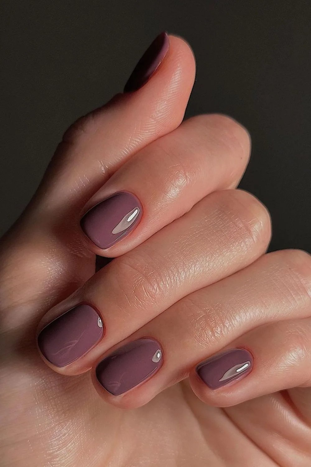 Unhas esmaltadas em tom roxo escuro, estilo ideal para o inverno.