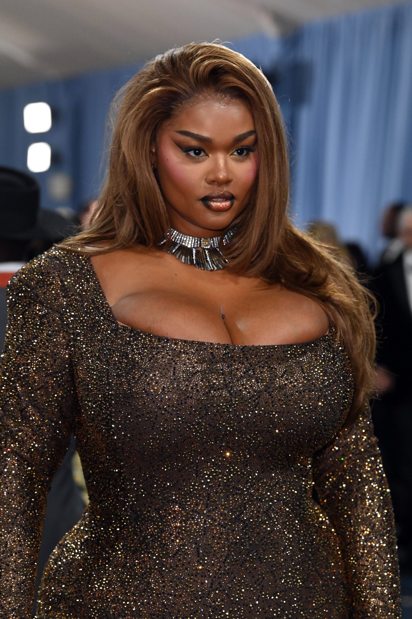 Mulher em vestido brilhoso e elegante, destaque para a beleza das celebridades.