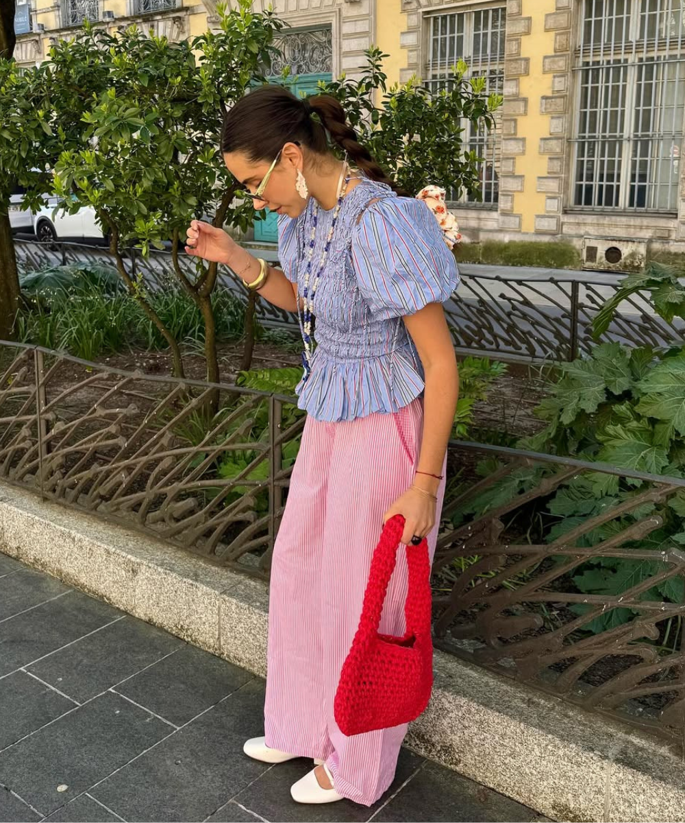 Mulher em pé usando uma das indicações de calças para trabalho colorida.