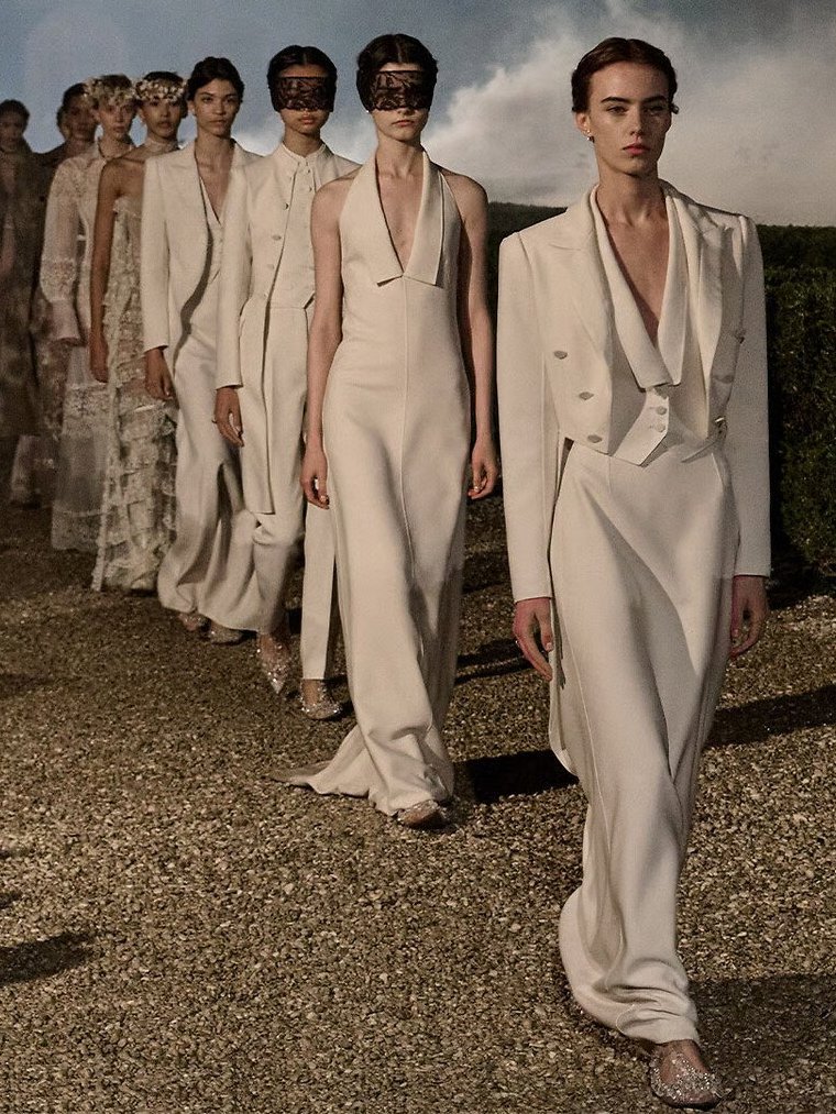 Desfile de moda com modelos em roupas brancas elegantes. Jonathan Anderson.