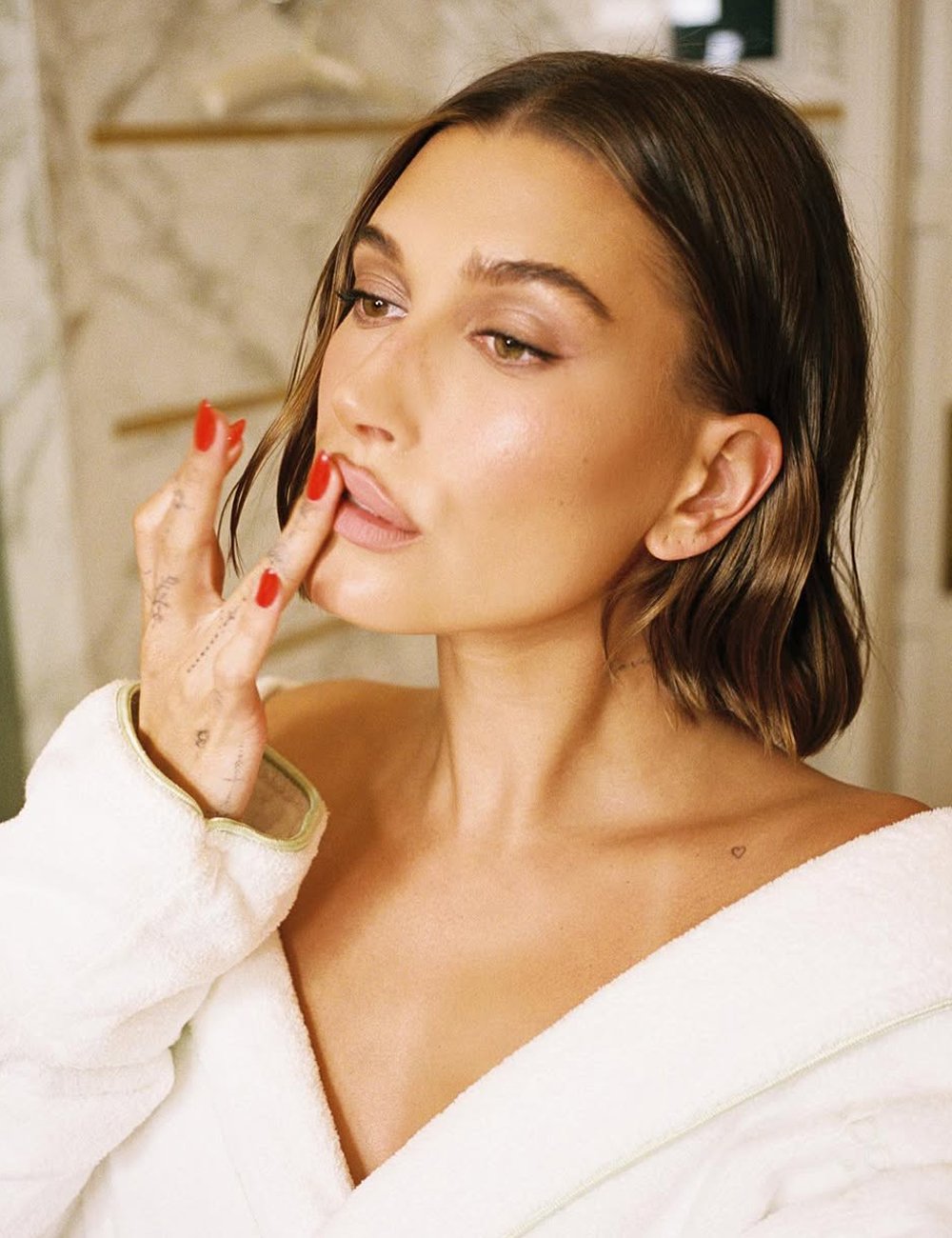 Hailey Bieber aplica hidratante labial