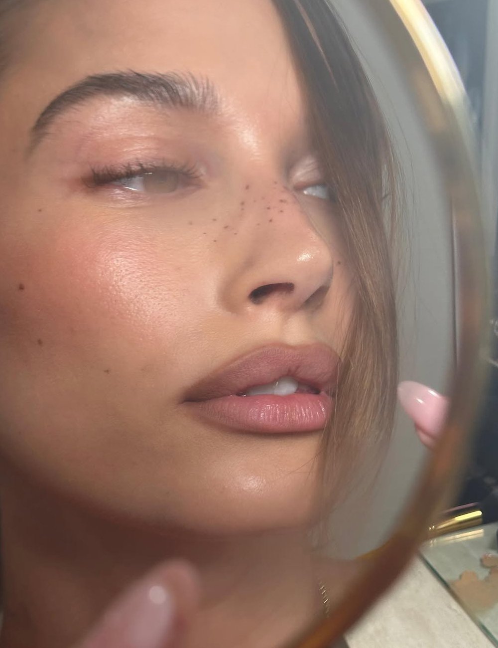 Hailey Bieber aplica hidratante labial