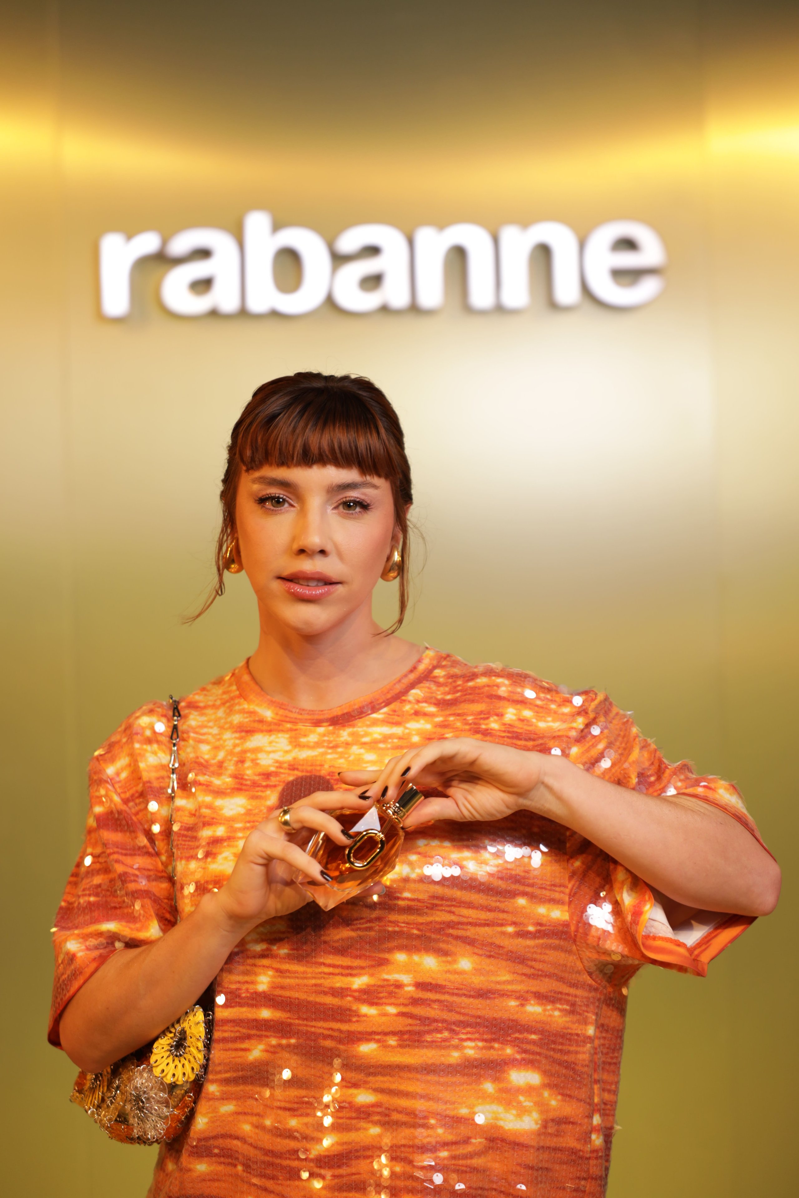 alice wegmann com vestido laranja posando com o novo Million Gold for Her Pure Jasmine um perfume feminino marcante