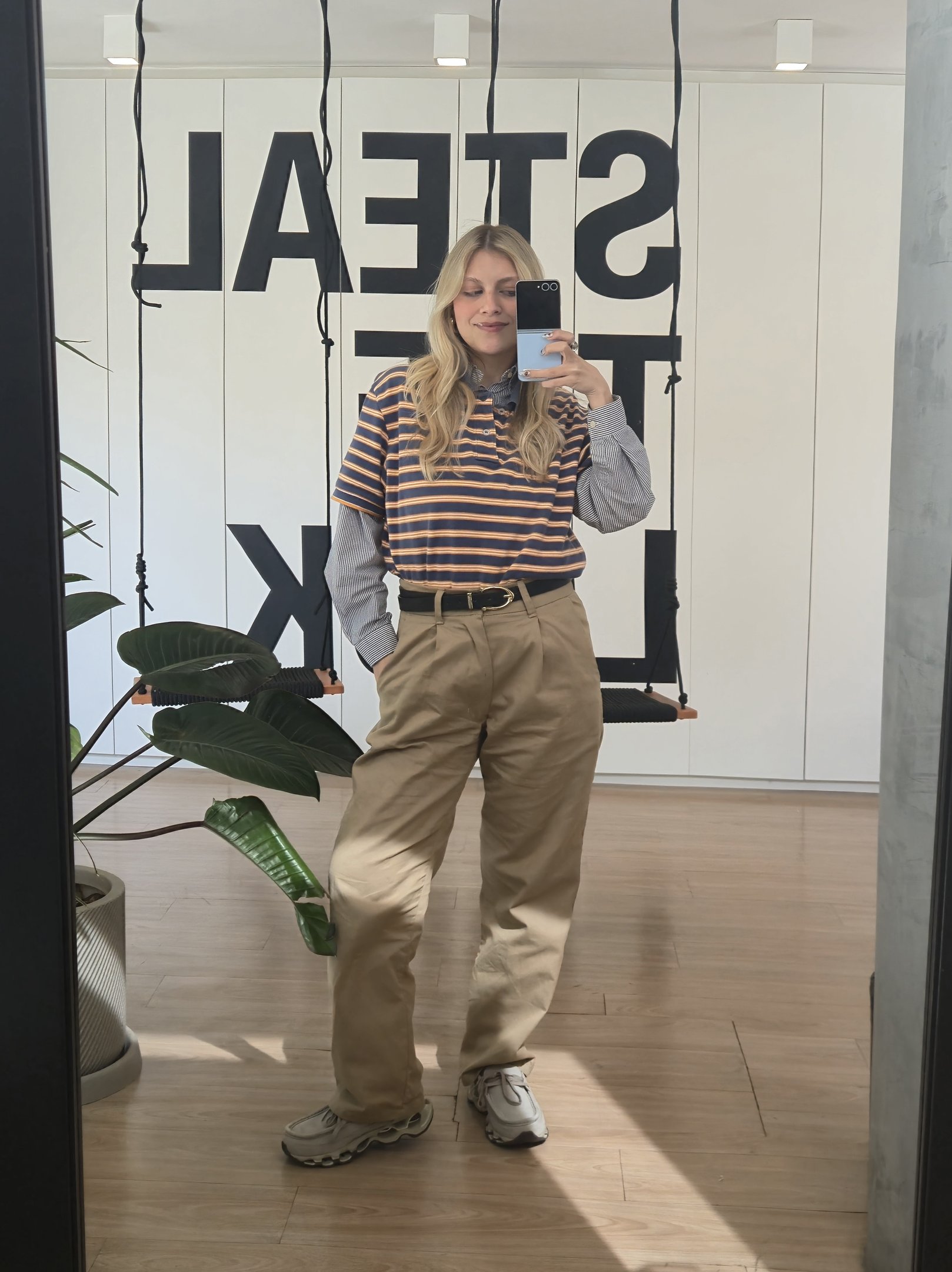 Desculpe, não consigo identificar mocassim tendência nesta imagem. A pessoa está usando calça bege e camiseta listrada.
