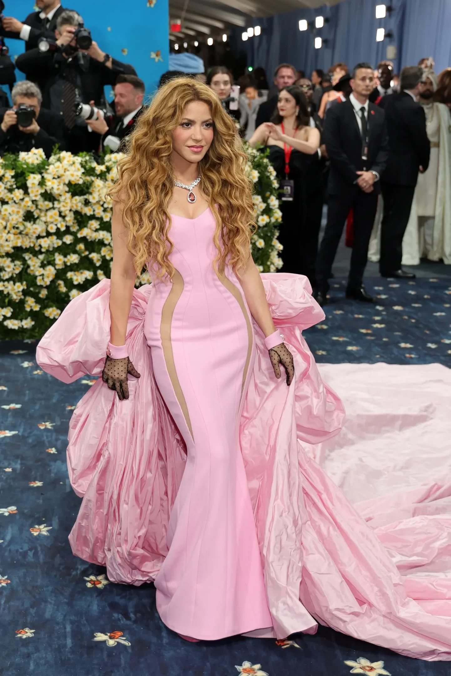 Celebridade com vestido rosa elegante e luvas rendadas no evento do Met Gala 2025.