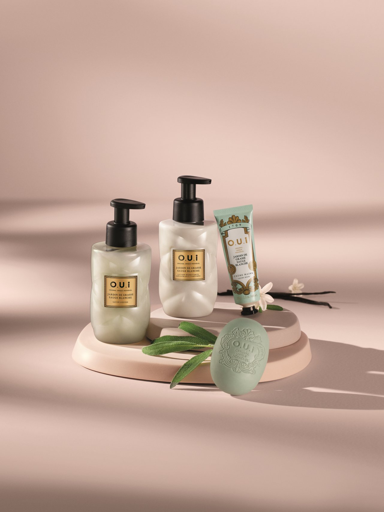 Produtos de cuidados pessoais Jardin de Grasse Sauge Blanche sobre pedestal, incluindo sabonete, loção e creme.