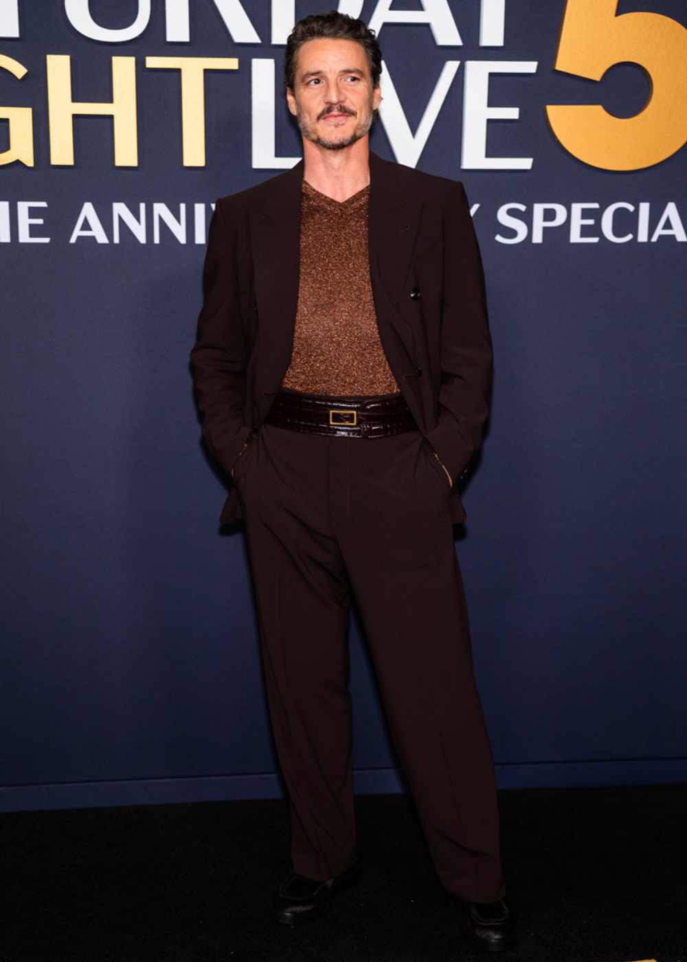 Pedro Pascal usando terno marrom para evento do programa de TV norte-americano, Saturday Night Live.