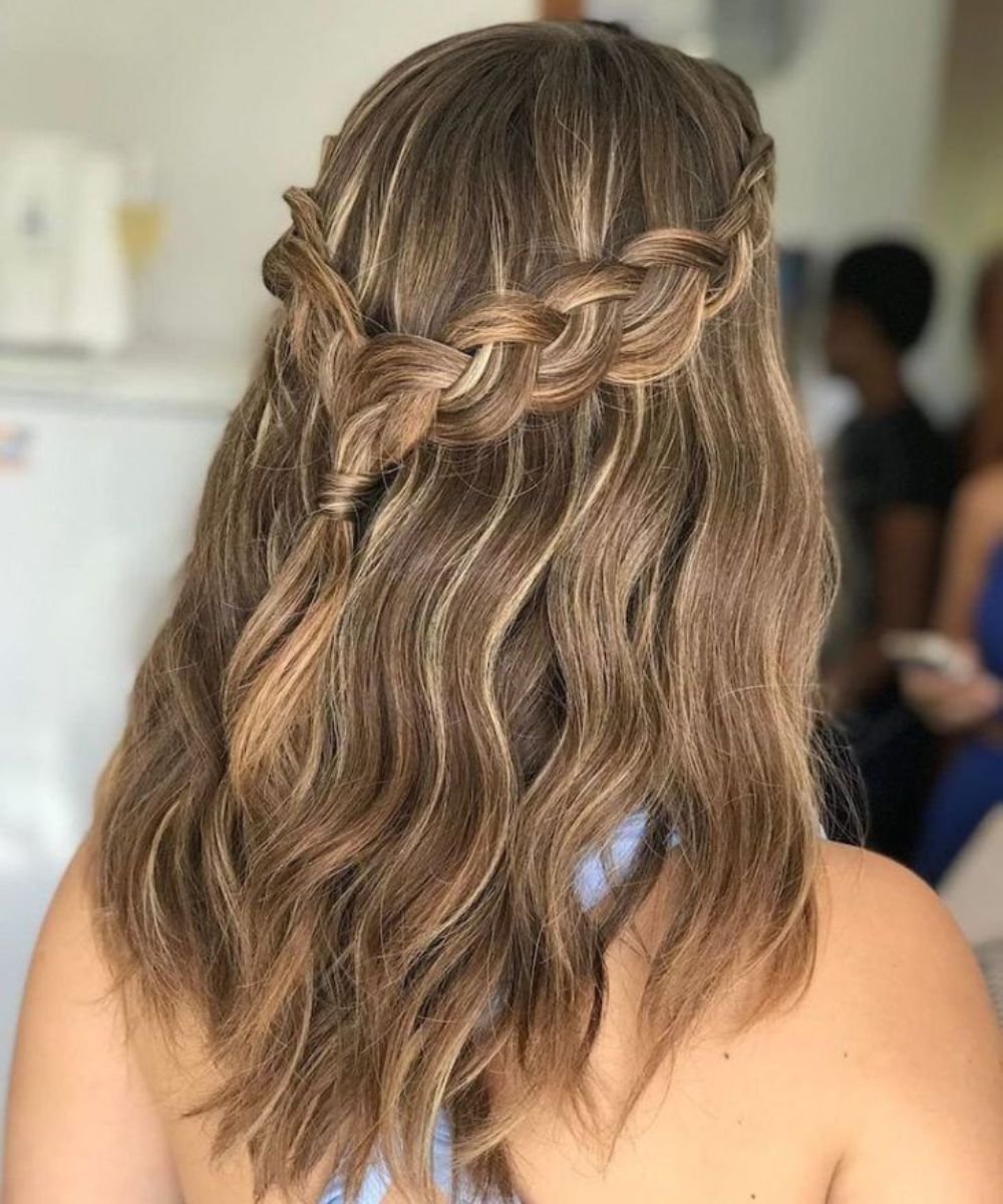 Cabelo loiro ondulado com trança fácil no topo formando um padrão delicado.
