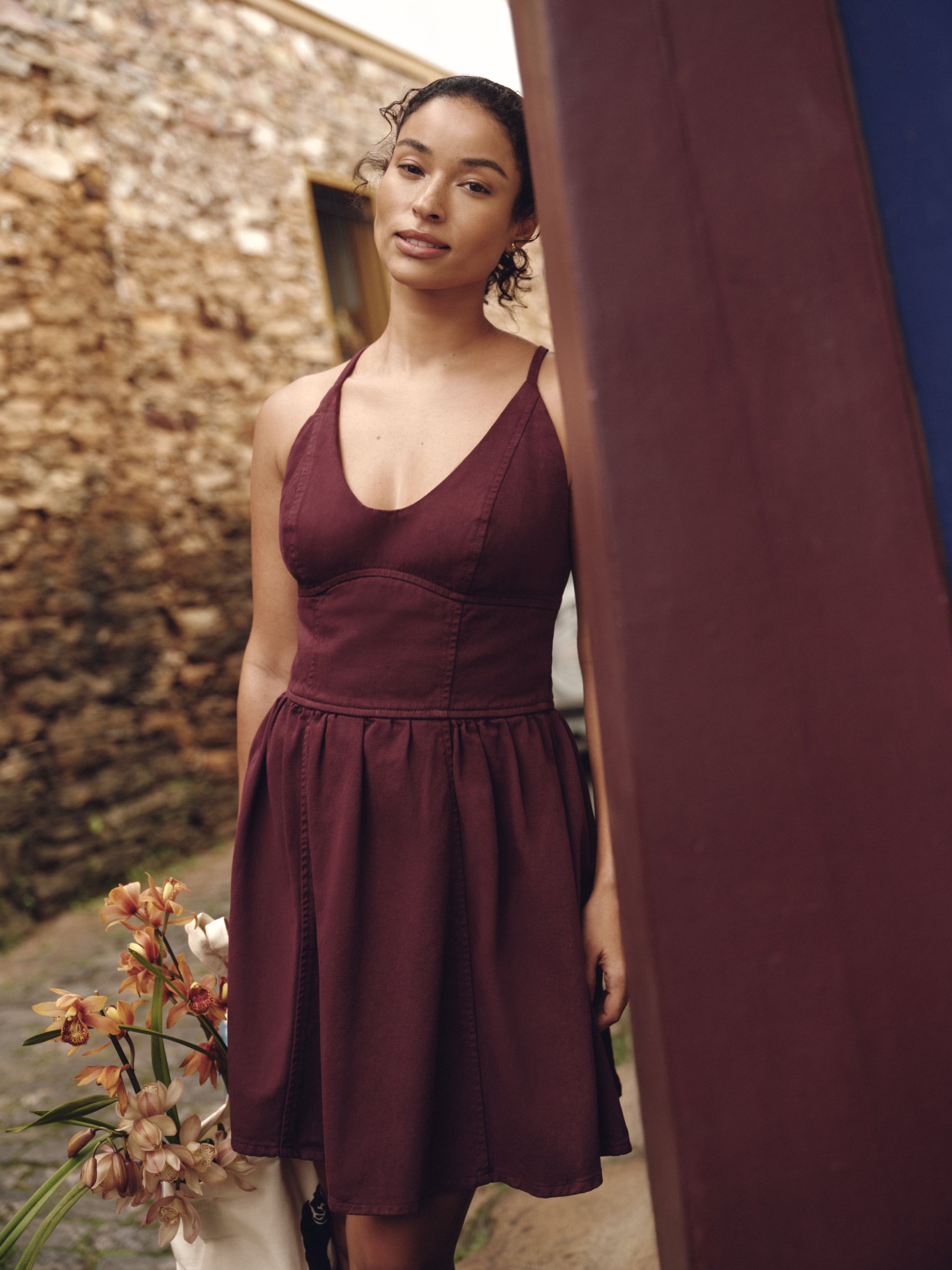 mulher posando para a foto vestindo vestido vinho feito em tecido mais sustentável