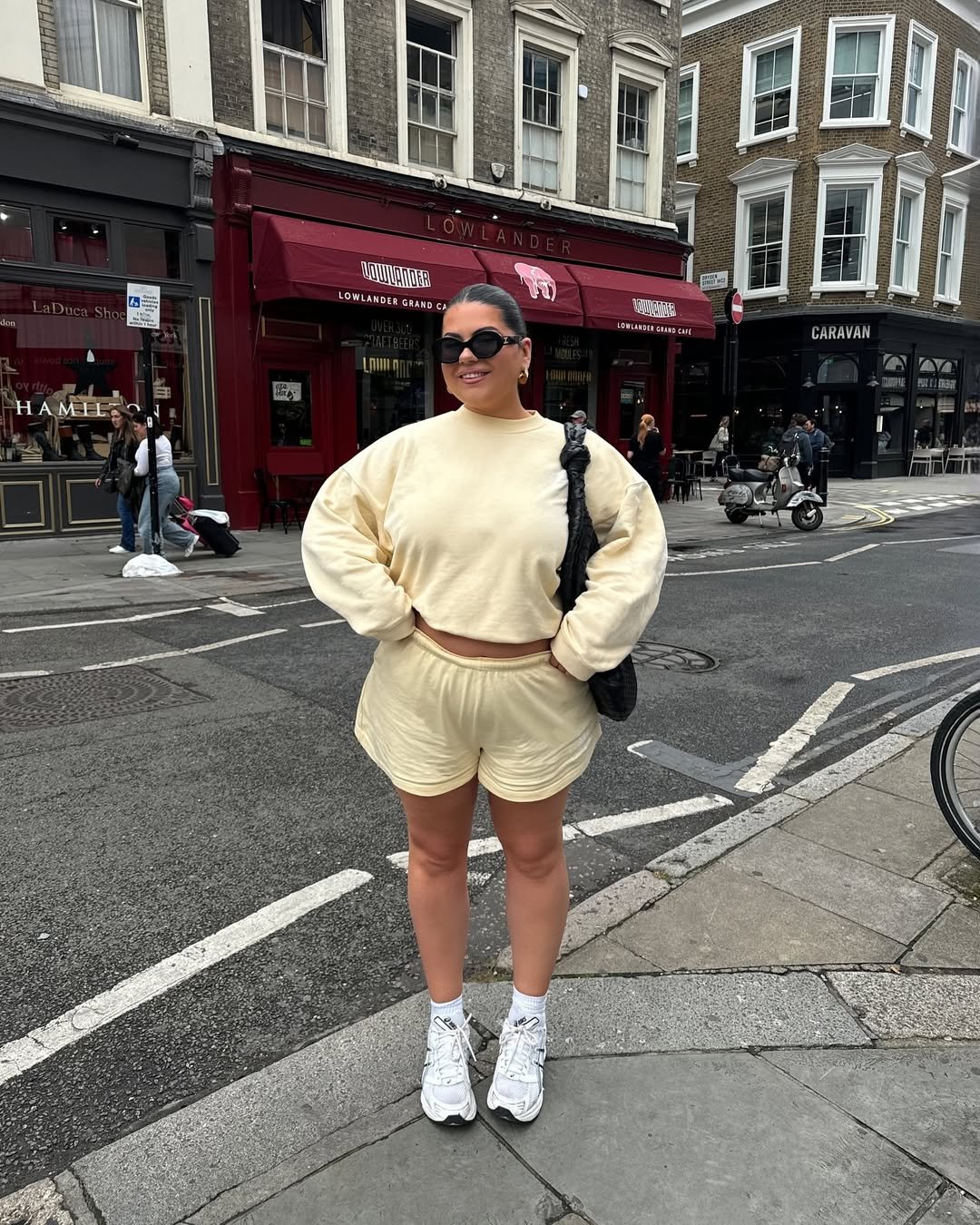 influenciadora usando shorts do estilo esportivo e blusa de moletom amarelas