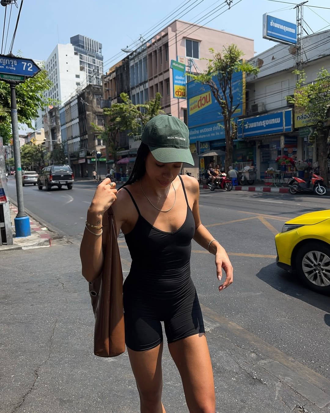 influenciadora usando macaquinho e boné verde, um dos looks inspiração para usar com os novos tênis de corrida coloridos de olympikus