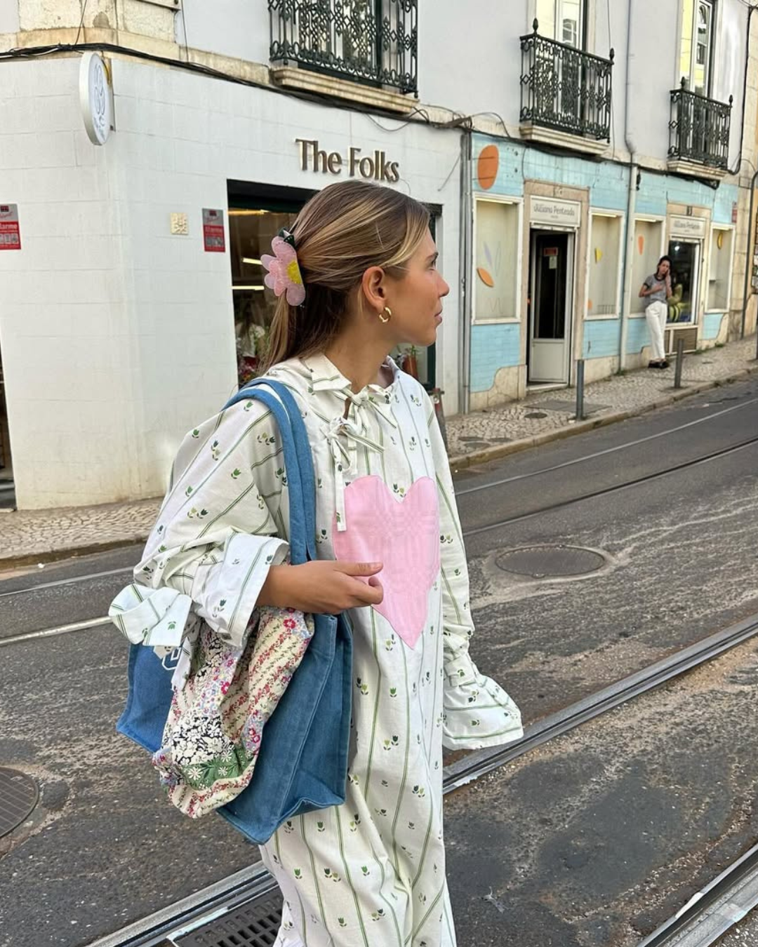 mulher posando para a foto com vestido romântico e tênis de corrida coloridos no pé