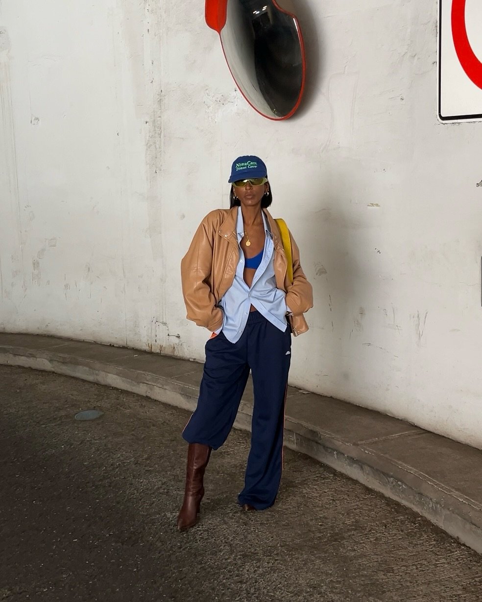 Pessoa usando jaqueta bege, camisa azul e boné, exemplificando truque de styling fácil com combinação casual e moderna.