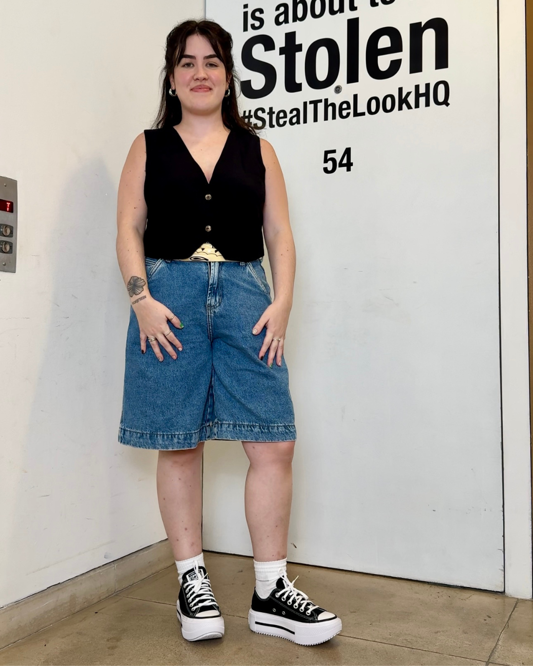 nicole usando bermuda jeans, colete de alfaiataria e converse