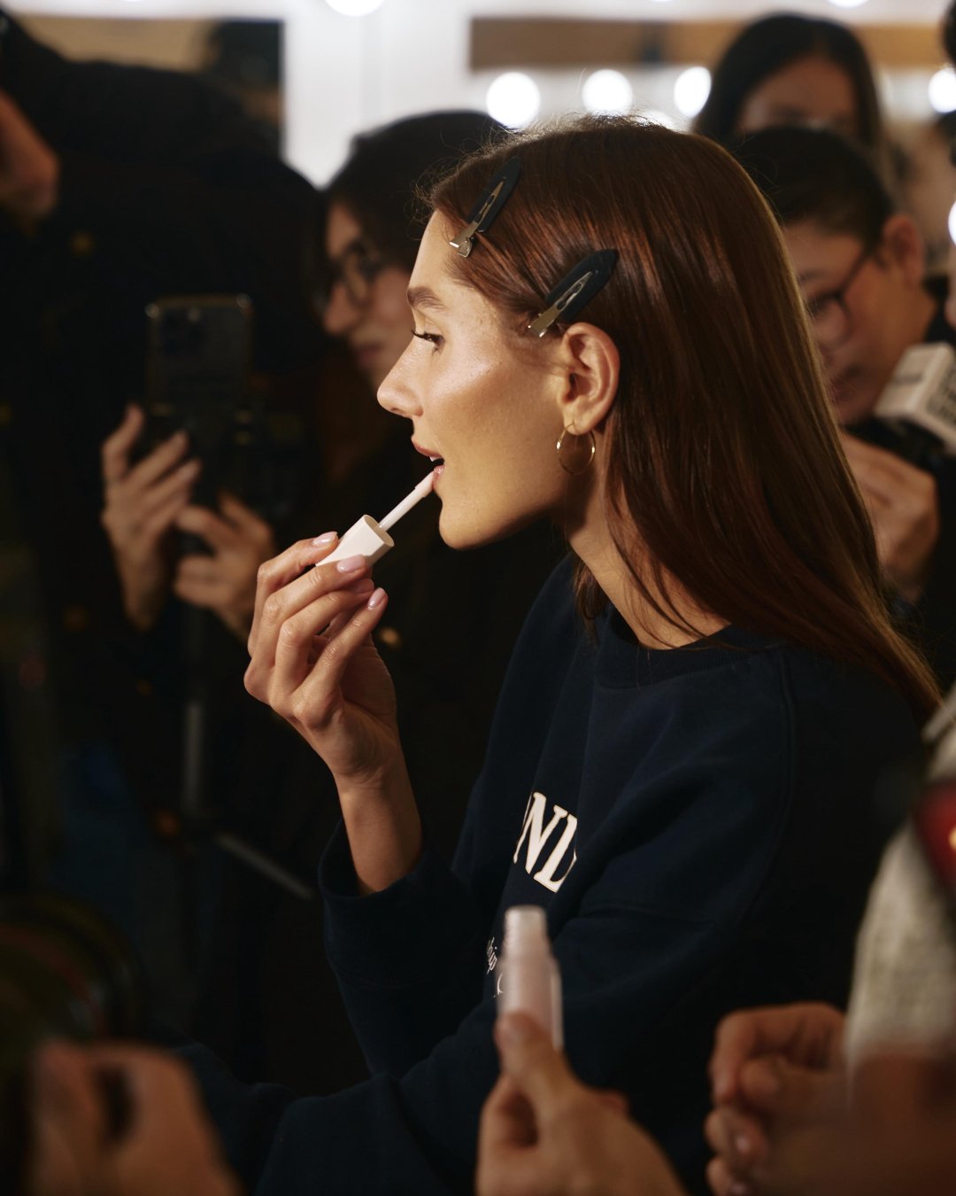 sasha meneghel no backstage do desfile da Mondepars passando lip oil