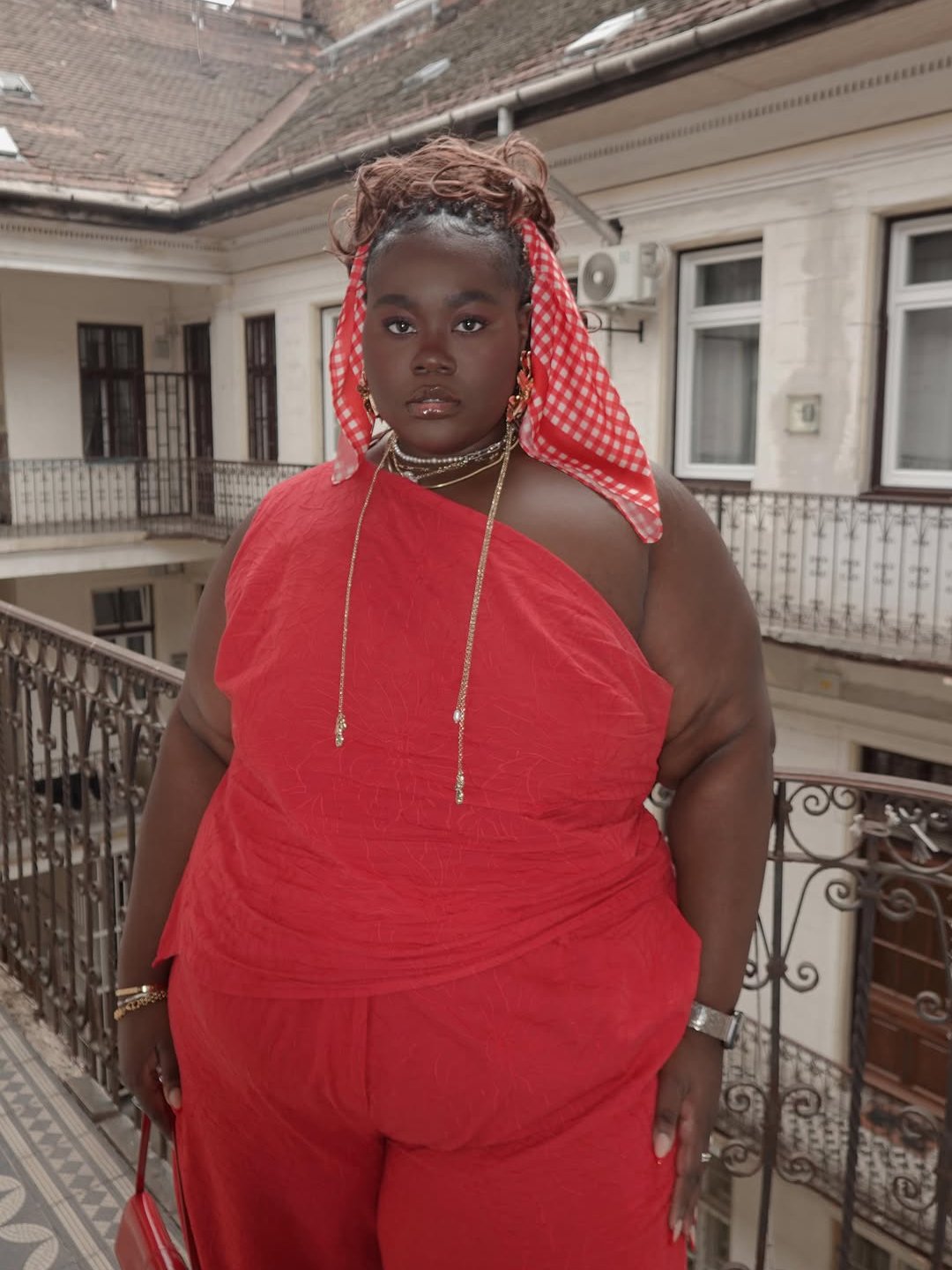 Mulher com acessórios e lenço vermelho.