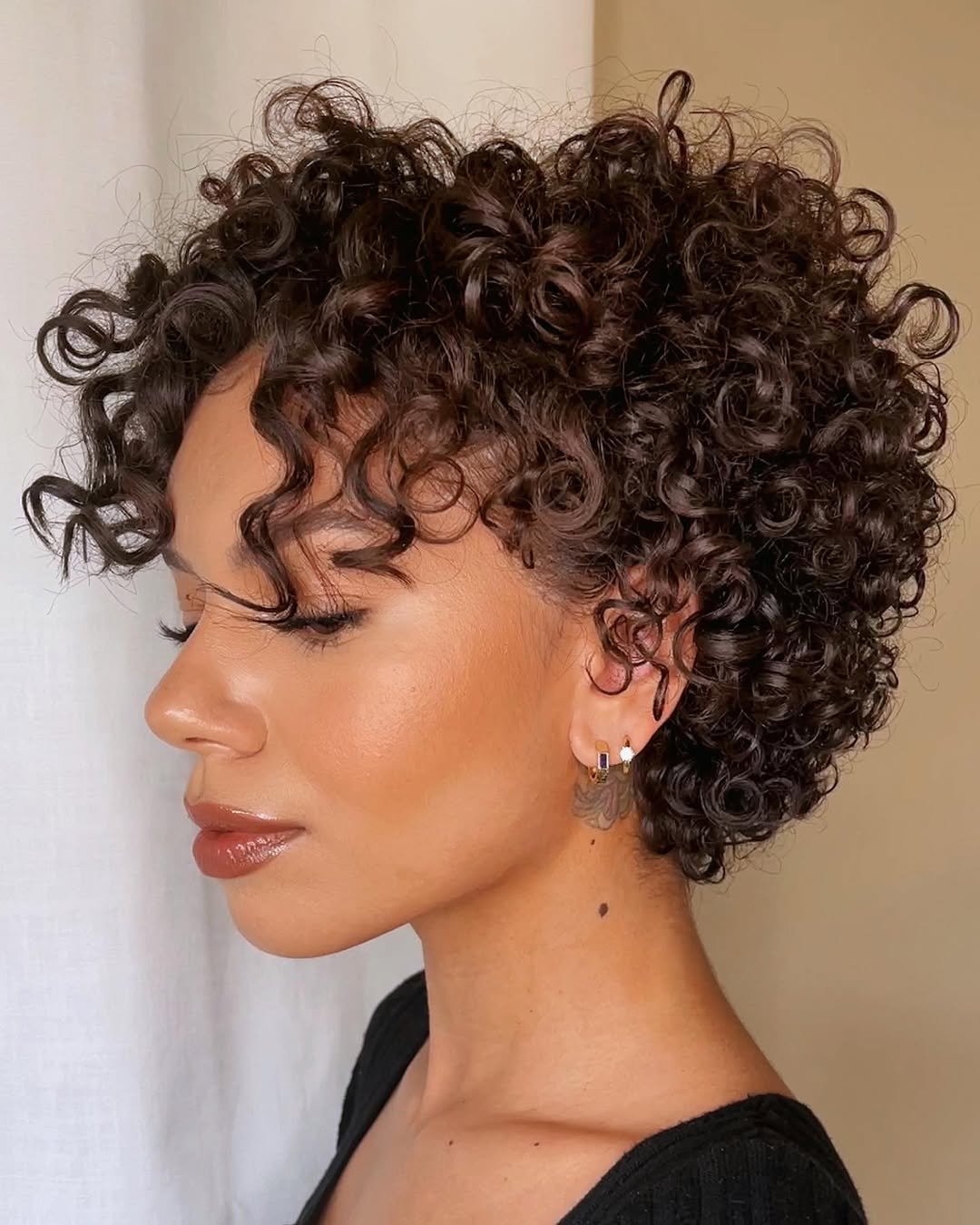 Cabelo cacheado em bixie cut, destacando cachos definidos e estilo moderno.